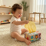Bébé jouant avec la boîte à mouchoirs Montessori