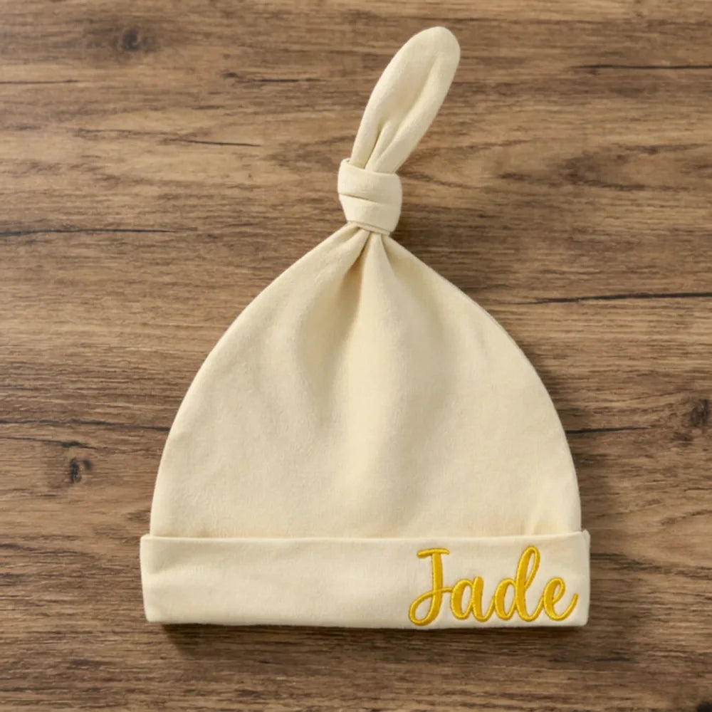 Bonnet de naissance beige à nœud, prénom Jade brodé en fil moutarde à droite du revers