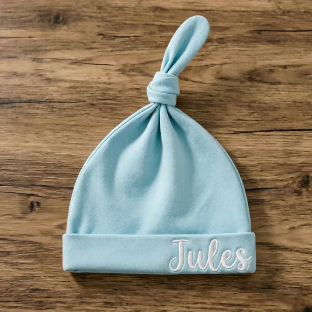 Bonnet de naissance bleu ciel à nœud, prénom Jules brodé en fil blanc à droite du revers