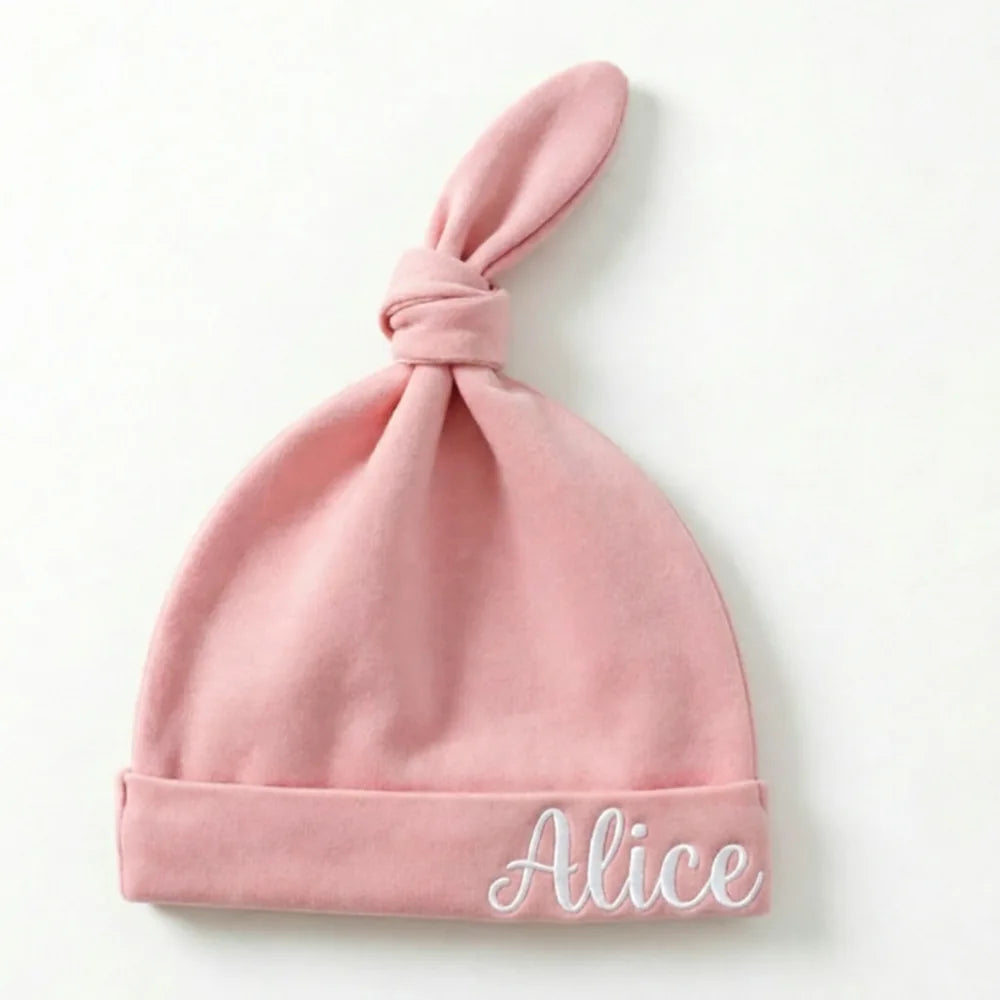 Bonnet de naissance rose poudré à nœud, prénom Alice brodé en fil blanc à droite du revers