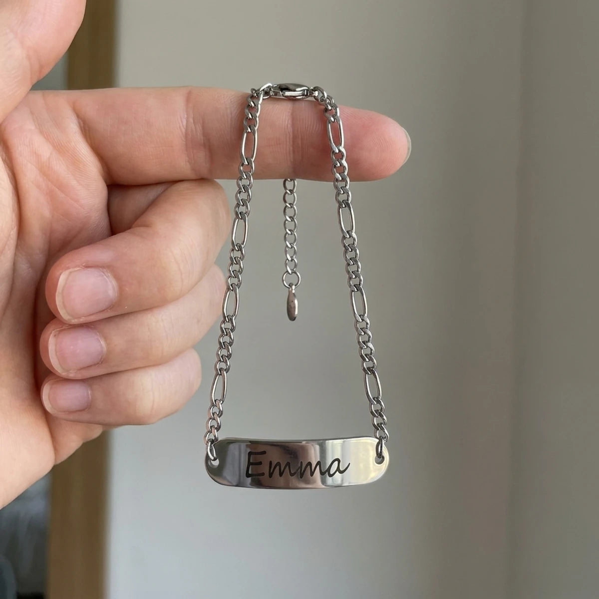 Bracelet bebe dore suspendu a un doigt d'adulte