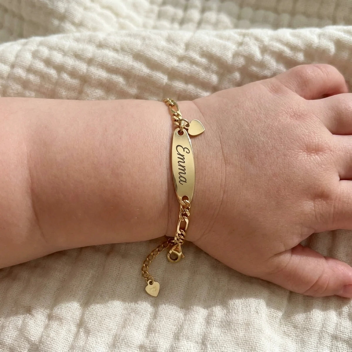 Bracelet gourmette dore au poignet d'un bebe