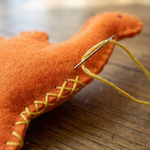 Détails des points de couture sur feutrine dinosaure