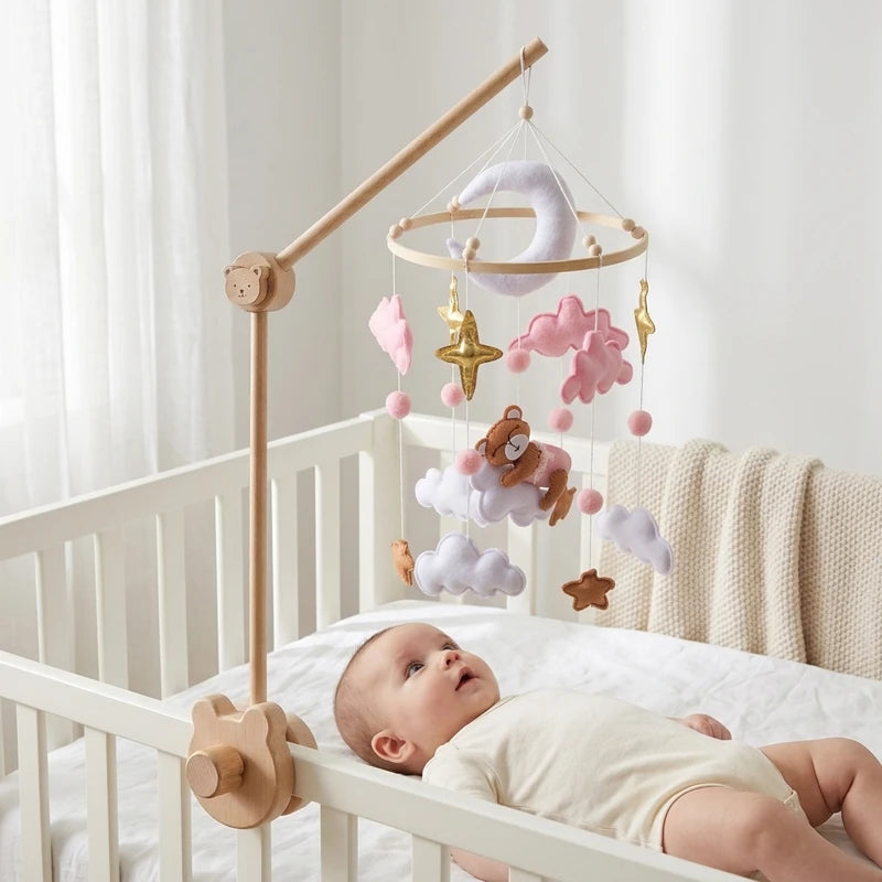 Bébé allongé dans son lit sous le mobile Ourson nuages roses