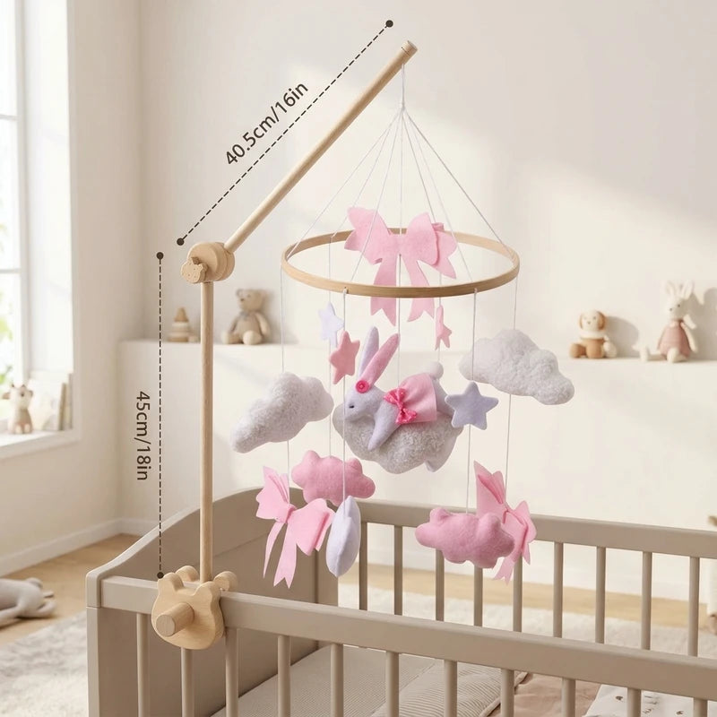 Bébé allongé dans son lit sous le mobile Lapin rose et nuages