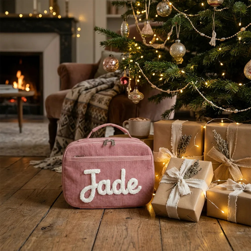 Sac à goûter rose brodé Jade sous le sapin de Noël parmi les cadeaux